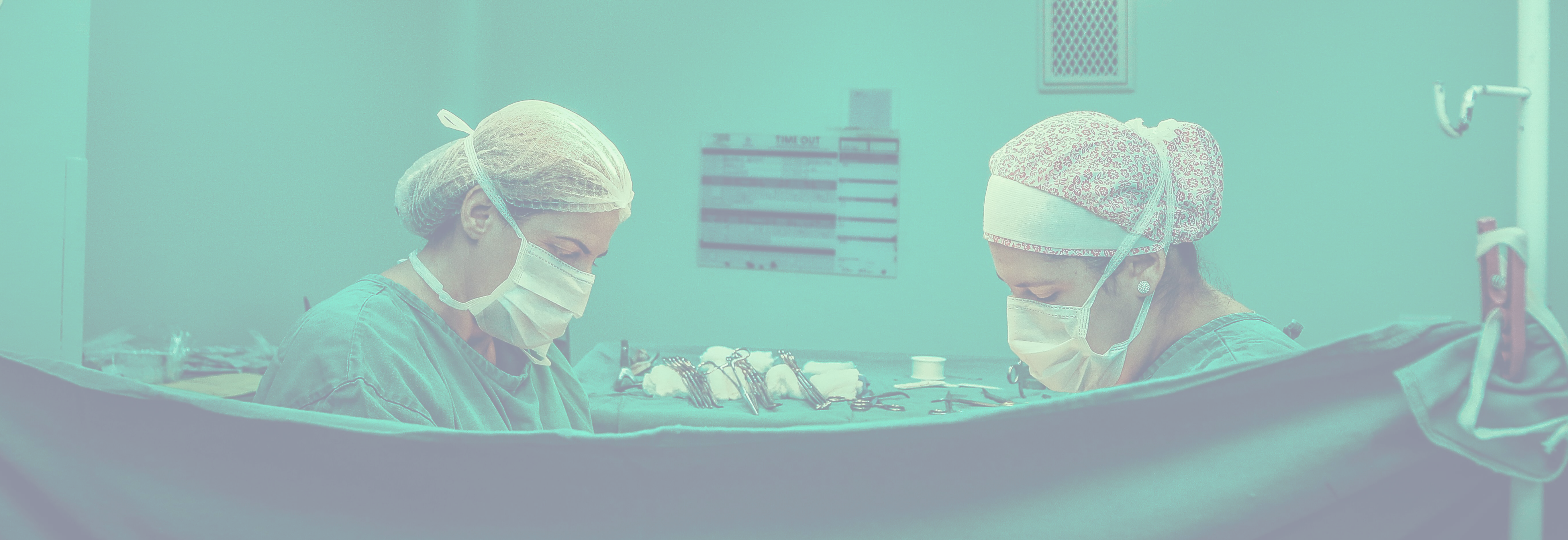 Duas médicas realizando um procedimento cirúrgico.